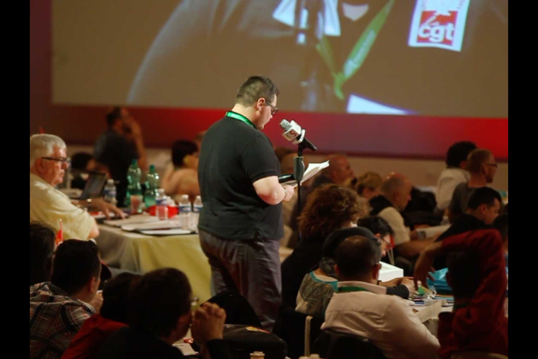 Der Gewerkschafter Tenessee Garcia liest seine Eingabe am Mikrophon vor  Fotografie von Heiko Schäfer