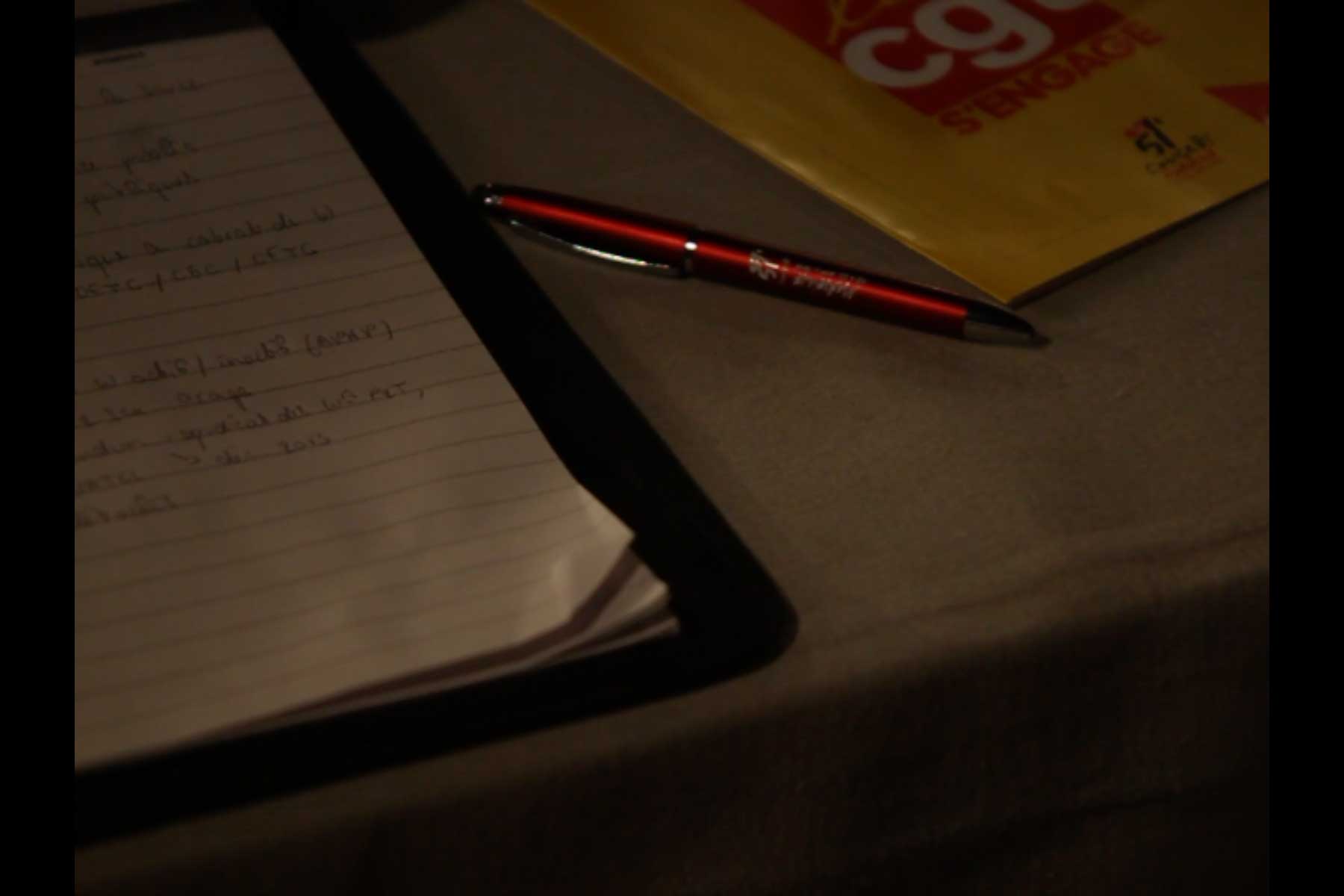 Nahaufnahme von einer handgeschriebenen Notiz, einem Kugelschreiber und einer CGT-Broschüre auf einem Tisch  Fotografie von Heiko Schäfer