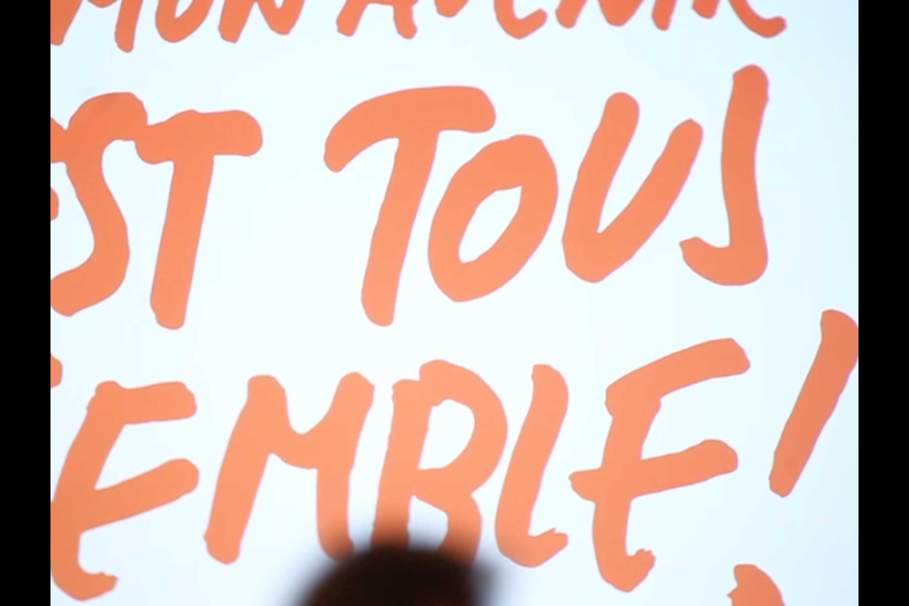 Projektion mit einer Grafik in rot, die den Slogan 