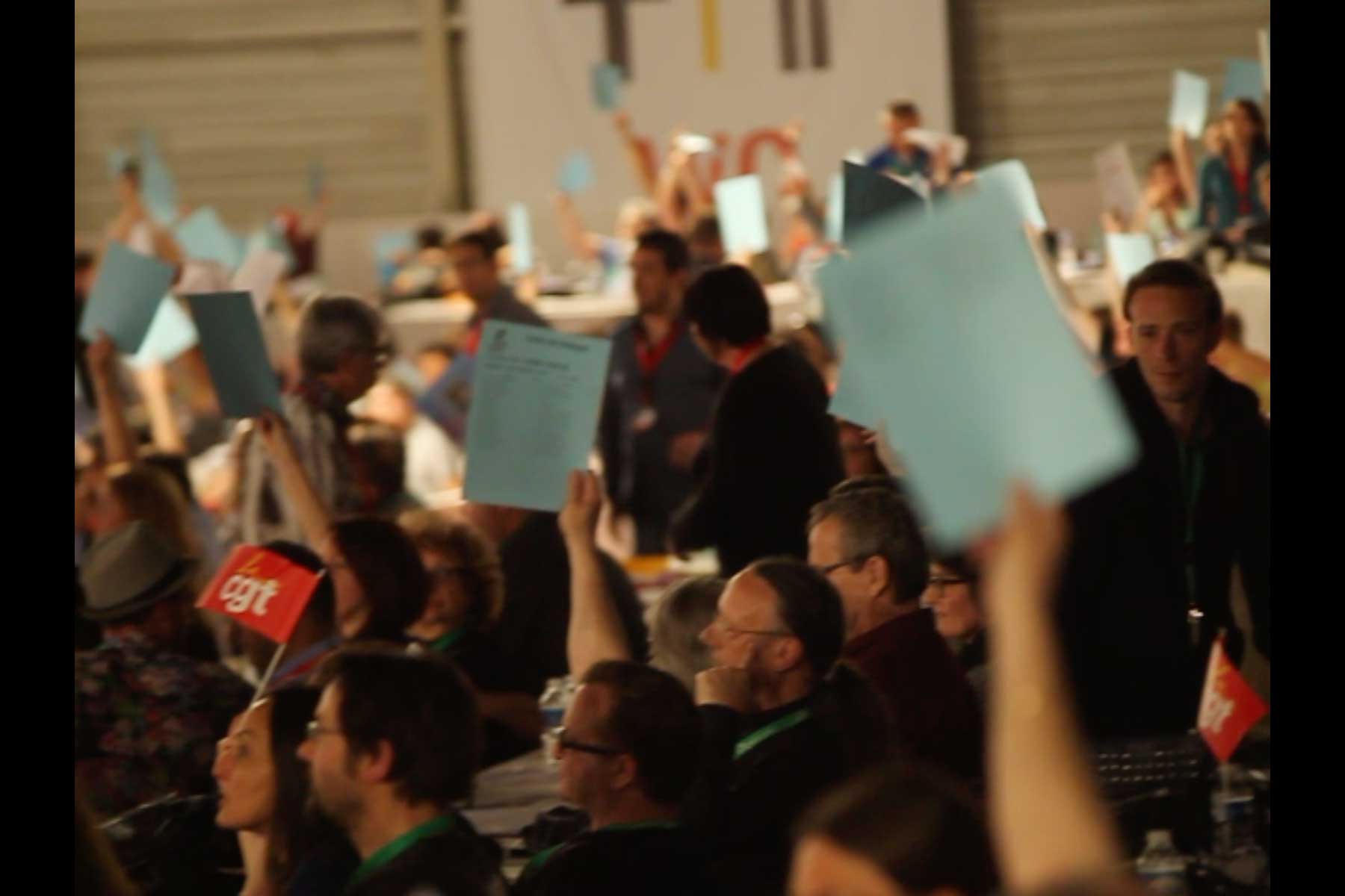 Abstimmung auf dem Kongress der CGT. Die Gewerkschafter:innen halten Blätter und Fähnchen in die Höhe  Fotografie von Heiko Schäfer