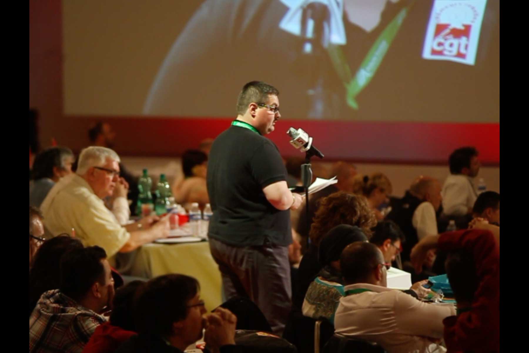 Der Gewerkschafter Tenessee Garcia liest seine Eingabe am Mikrophon vor  Fotografie von Heiko Schäfer