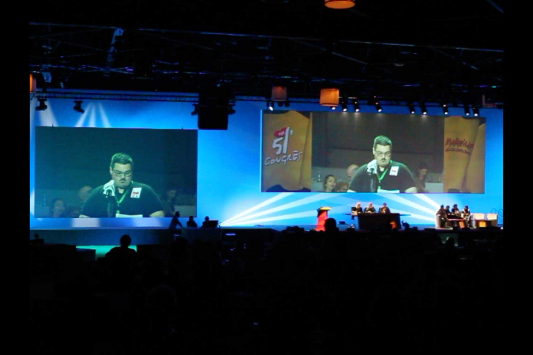 Eine Projektion zeigt den Gewerkschafter Tenessee Garcia, der seine Eingabe am Mikrophon vorliest  Fotografie von Heiko Schäfer