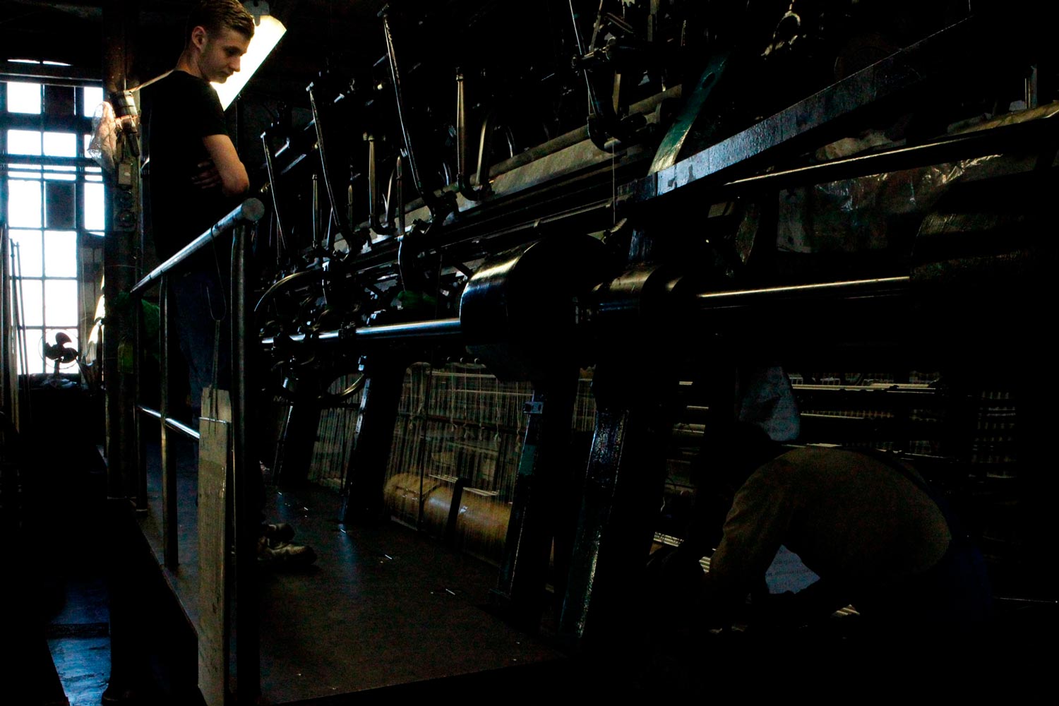 Der junge Arbeiter Matthieu steht mit seinem Vater am Leavers Webstuhl in der Textilfabrik Codentel  Fotografie von Heiko Schäfer