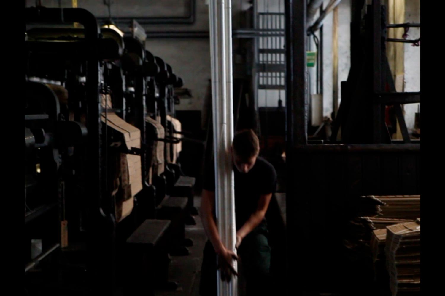 Der junge Textilarbeiter Matthieu trägt Textilspulen in der Textilfirma Codentel  Fotografie von Heiko Schäfer