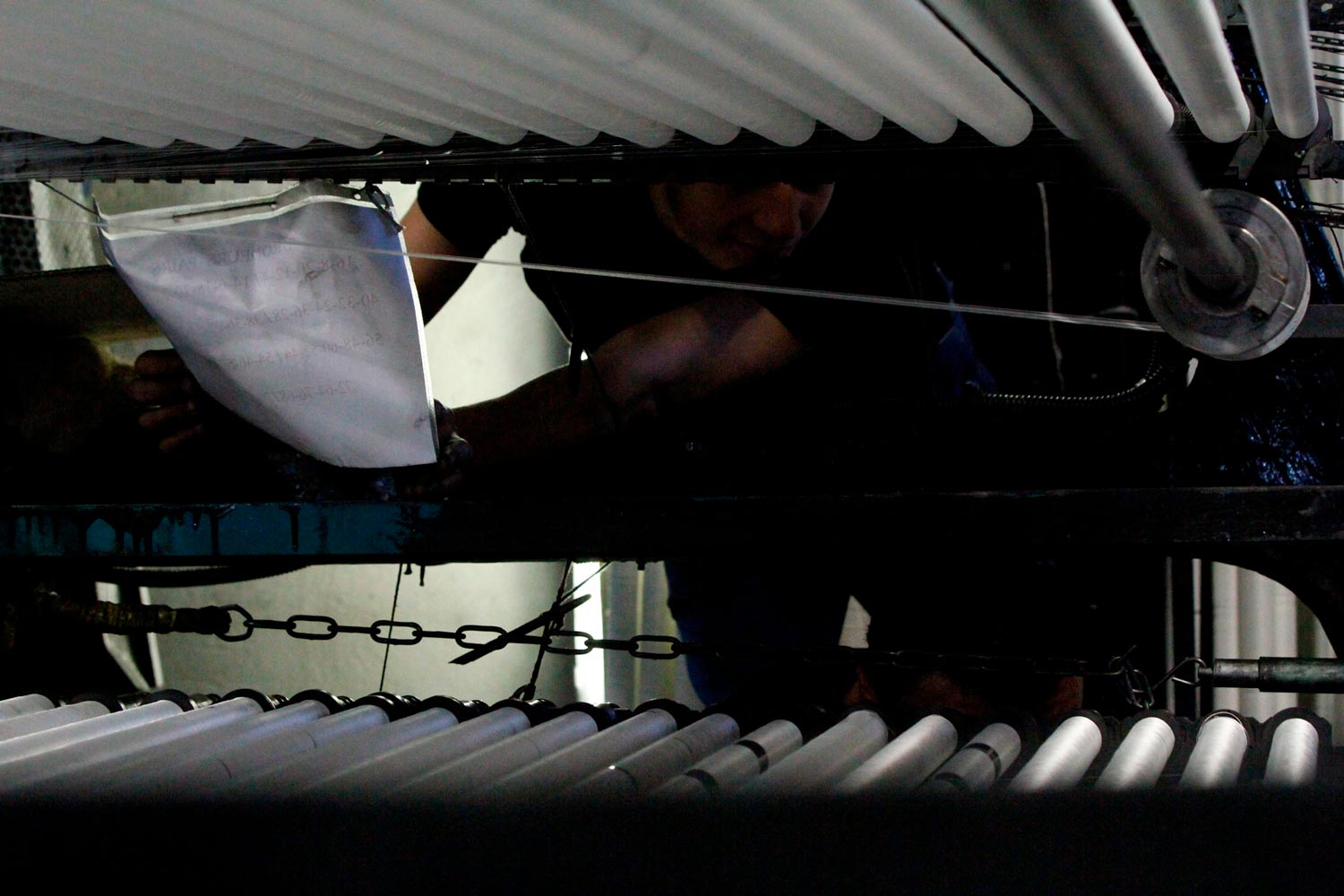 Der junge Arbeiter Matthieu arbeitet mit seinem Vater am Leavers Webstuhl in der Textilfabrik Codentel  Fotografie von Heiko Schäfer