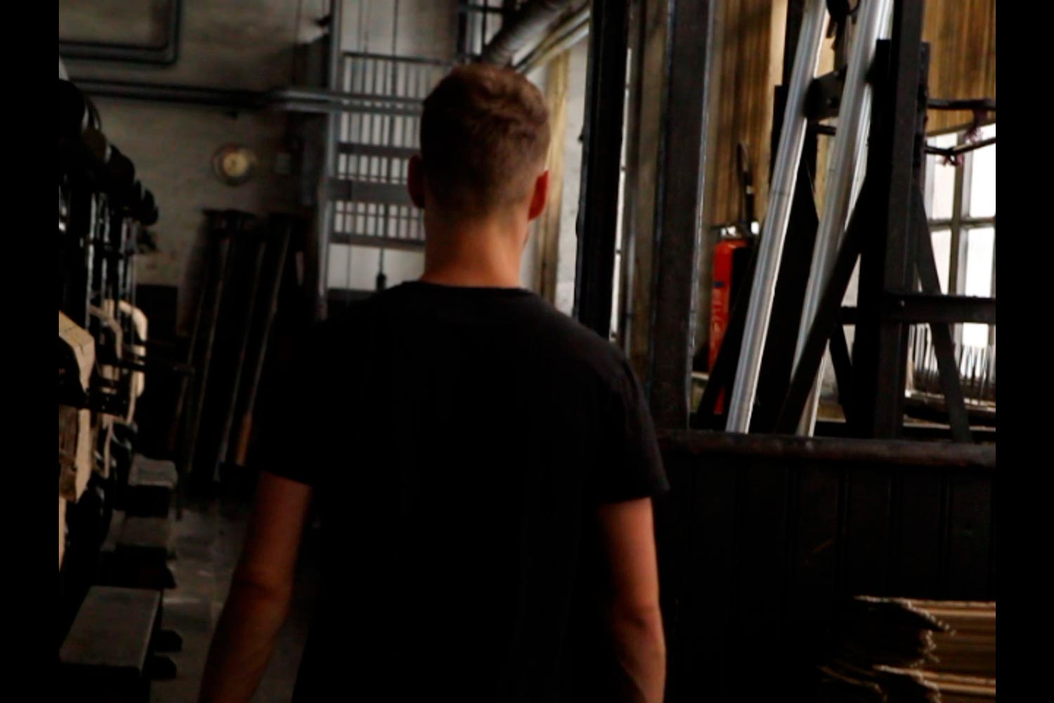 Der junge Textilarbeiter Matthieu läuft zum Aufzug in der Textilfirma Codentel  Fotografie von Heiko Schäfer