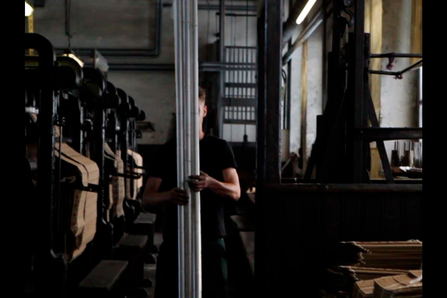 Der junge Textilarbeiter Matthieu trägt Textilspulen in der Textilfirma Codentel  Fotografie von Heiko Schäfer