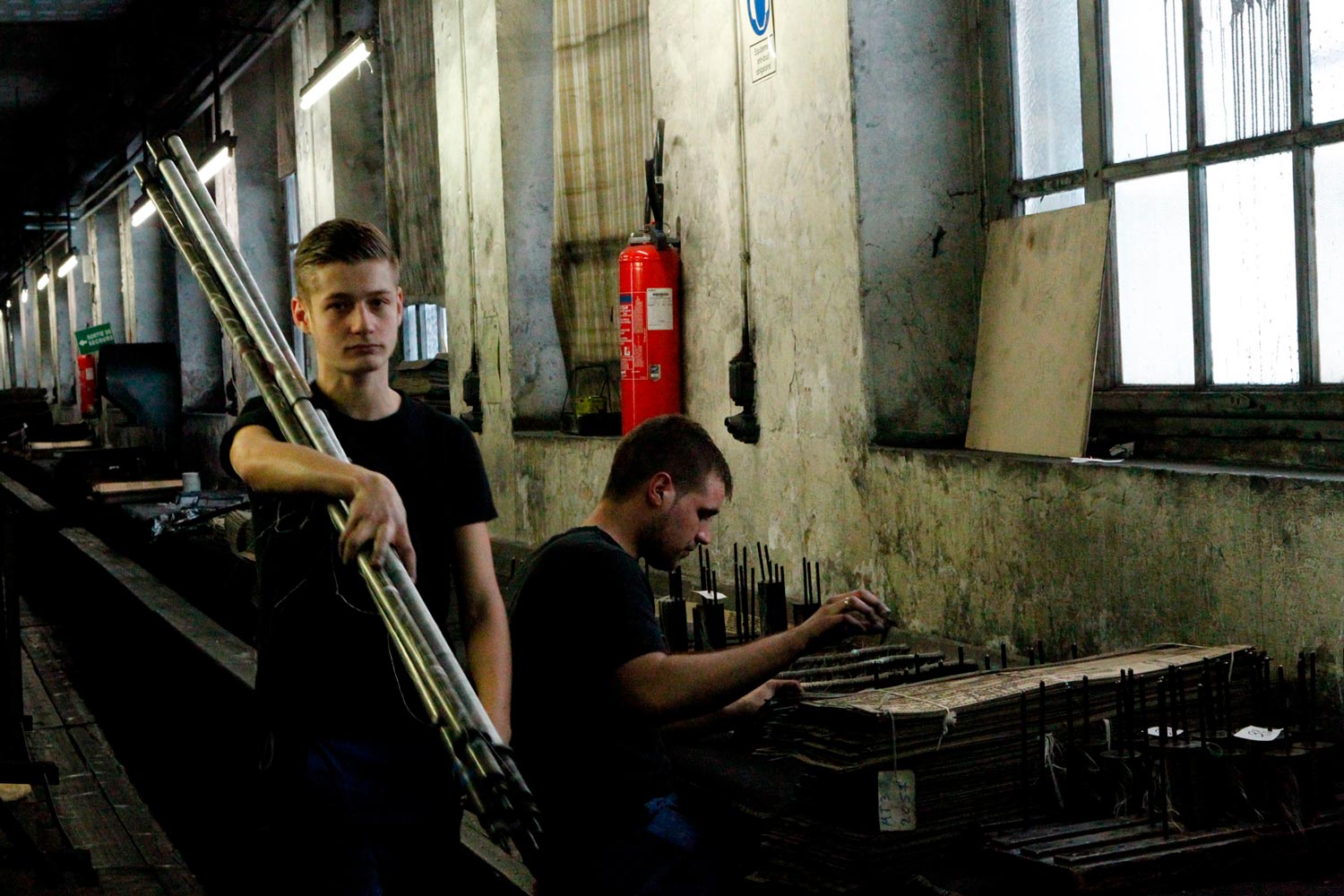 Der junge Textilarbeiter Matthieu trägt Textilspulen in der Textilfirma Codentel  Fotografie von Heiko Schäfer