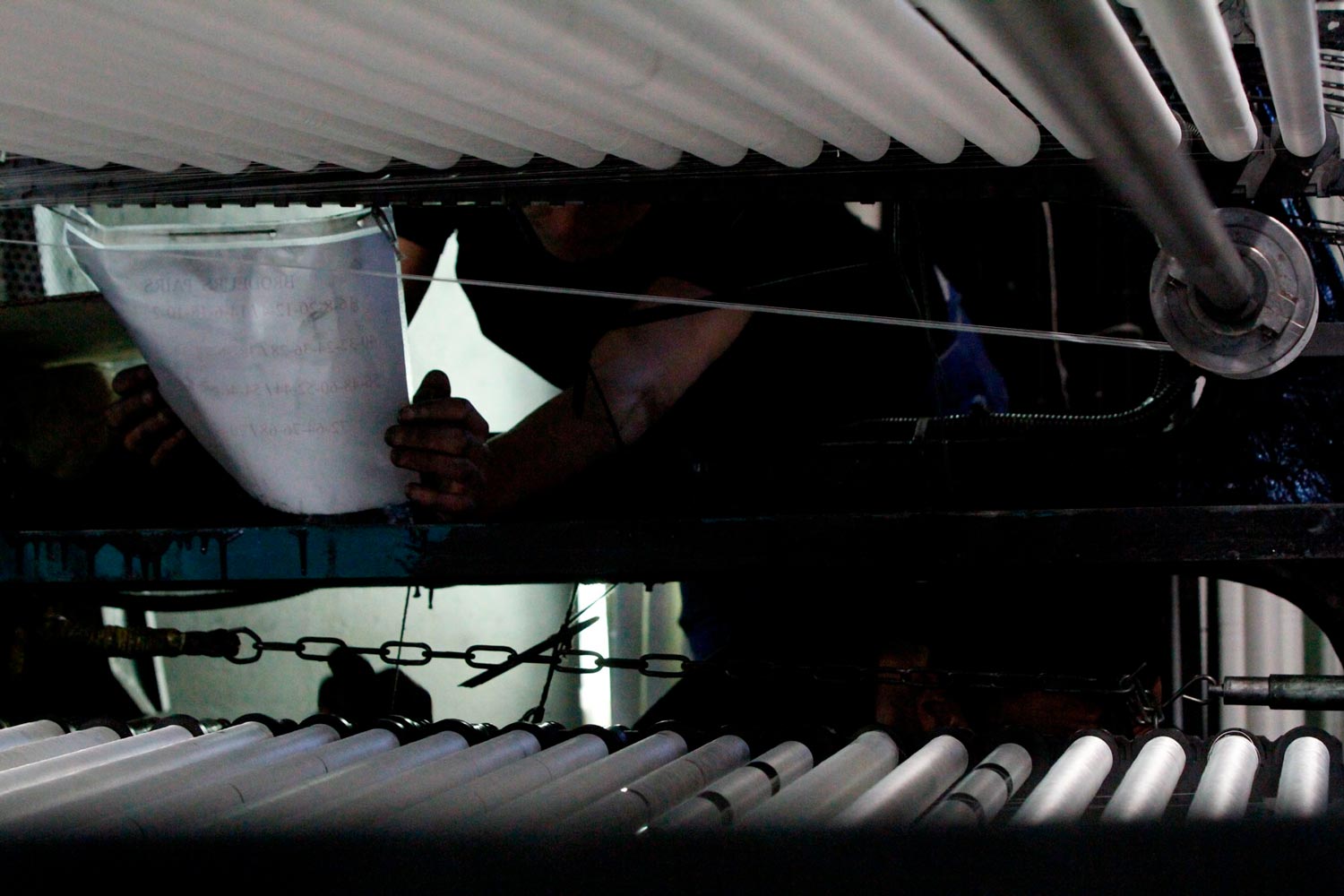 Der junge Arbeiter Matthieu arbeitet mit seinem Vater am Leavers Webstuhl in der Textilfabrik Codentel  Fotografie von Heiko Schäfer