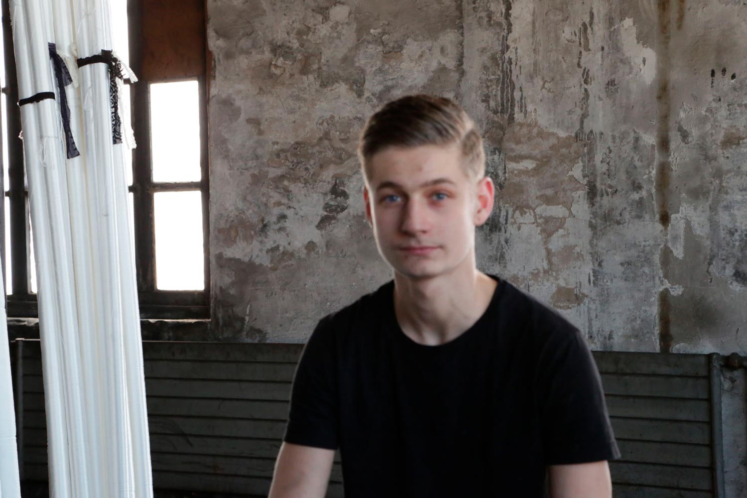 Der junge Arbeiter Matthieu im Interview in einer Halle der Textilfirma Codentel  Fotografie von Heiko Schäfer