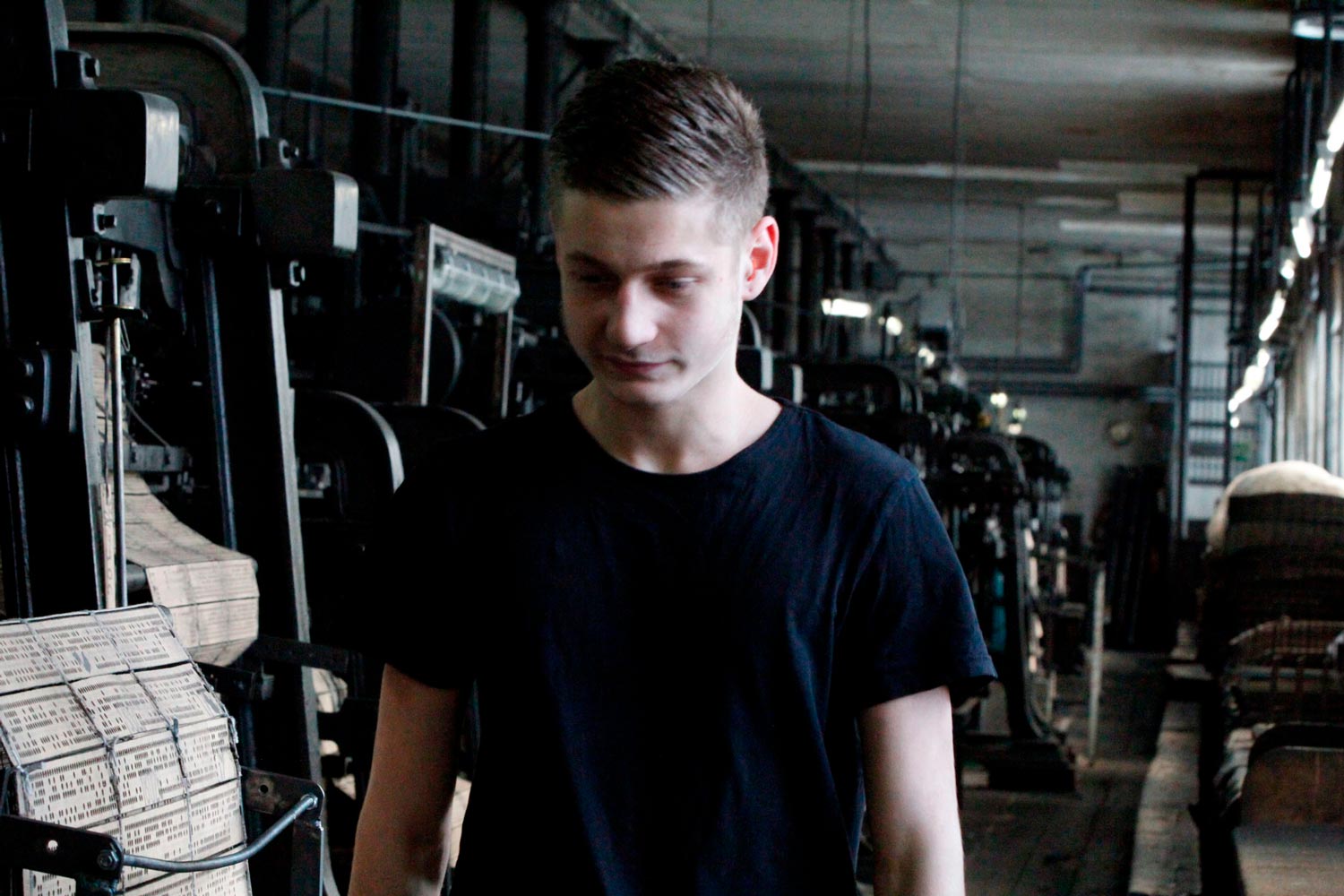 Der junge Arbeiter Matthieu läuft in einer Halle der Textilfirma Codentel  Fotografie von Heiko Schäfer