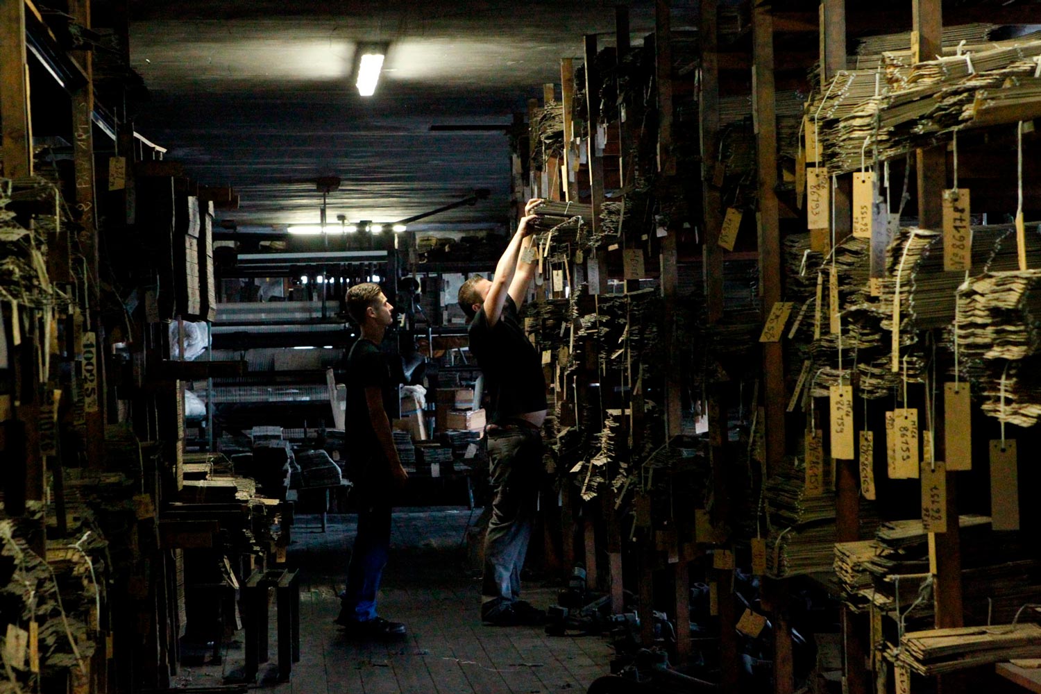 Der junge Arbeiter Matthieu im Lager der Textilfirma Codentel  Fotografie von Heiko Schäfer