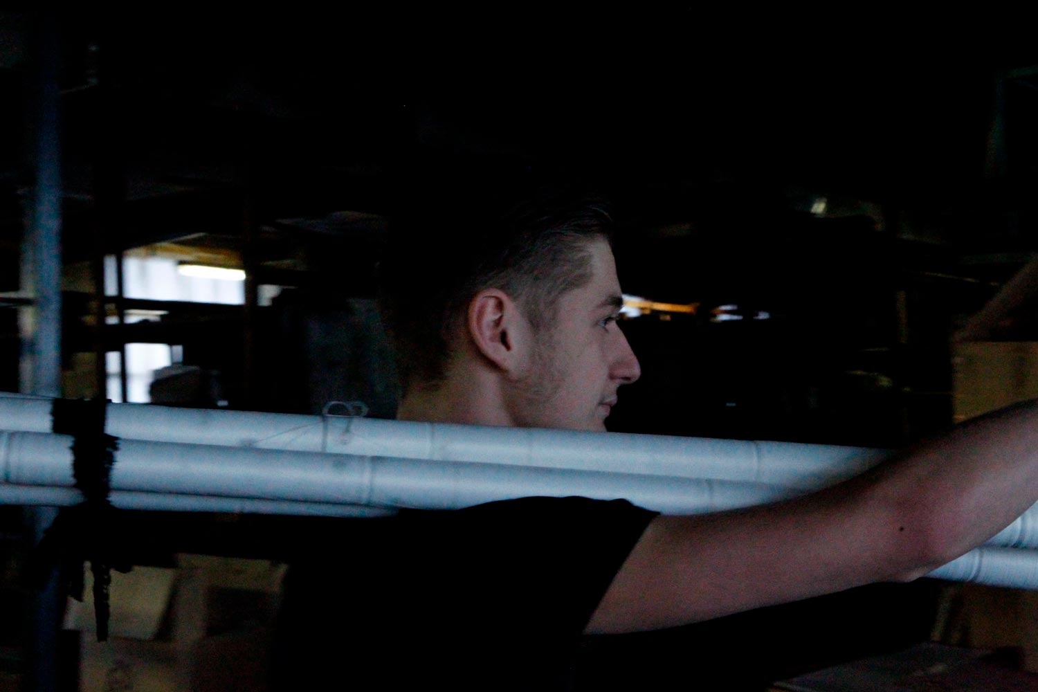 Der junge Textilarbeiter Matthieu trägt Textilspulen in der Textilfirma Codentel  Fotografie von Heiko Schäfer