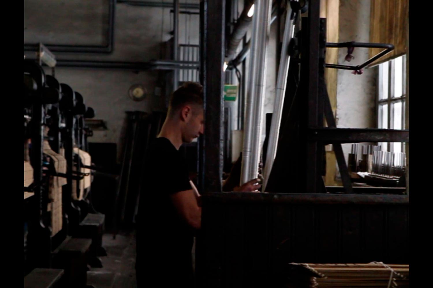 Der junge Textilarbeiter Matthieu am Aufzug in der Textilfirma Codentel  Fotografie von Heiko Schäfer