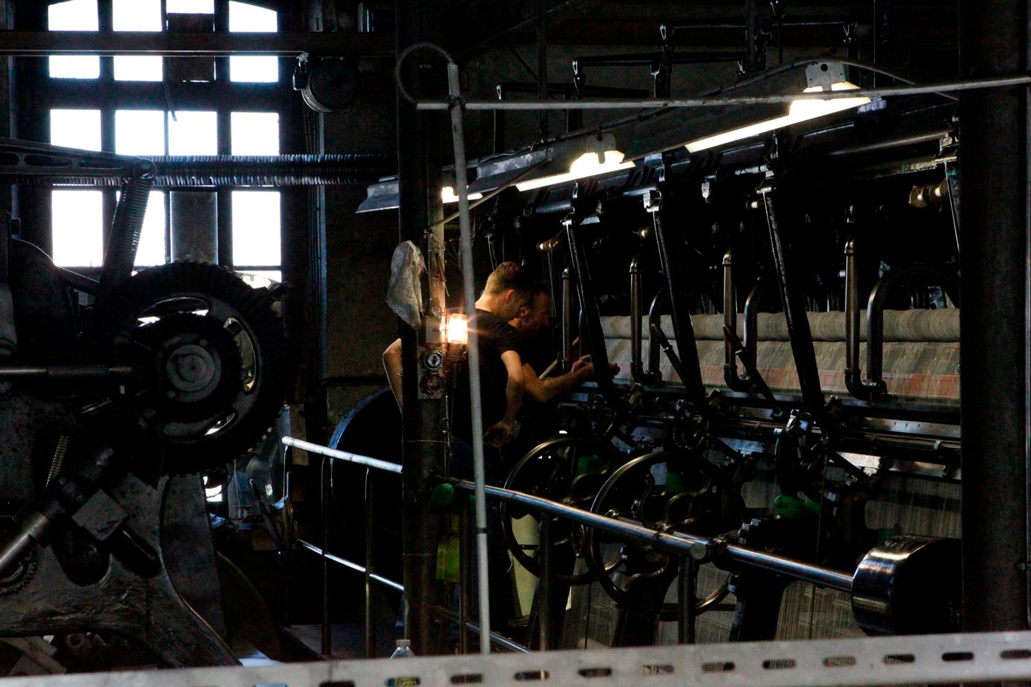 Der junge Arbeiter Matthieu arbeitet mit seinem Vater am Leavers Webstuhl in der Textilfabrik Codentel  Fotografie von Heiko Schäfer