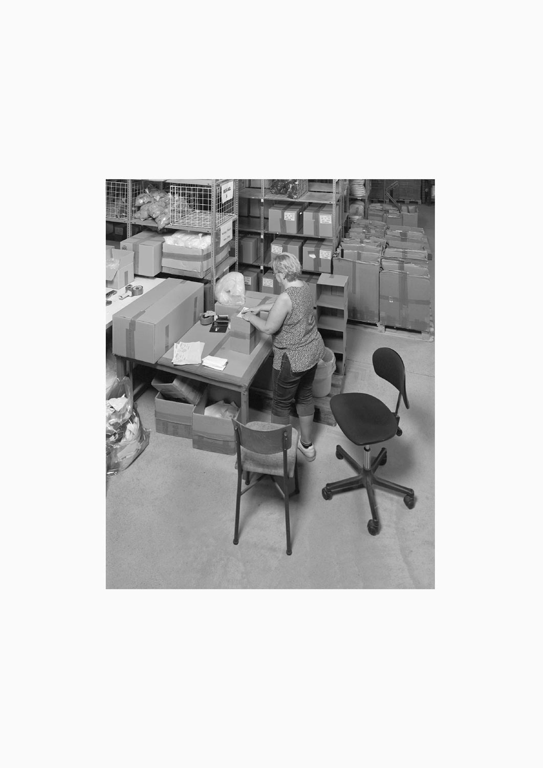 Eine Textilarbeiterin arbeitet an einem Arbeitstisch in der Firma M. Batex  Fotografie von Heiko Schäfer