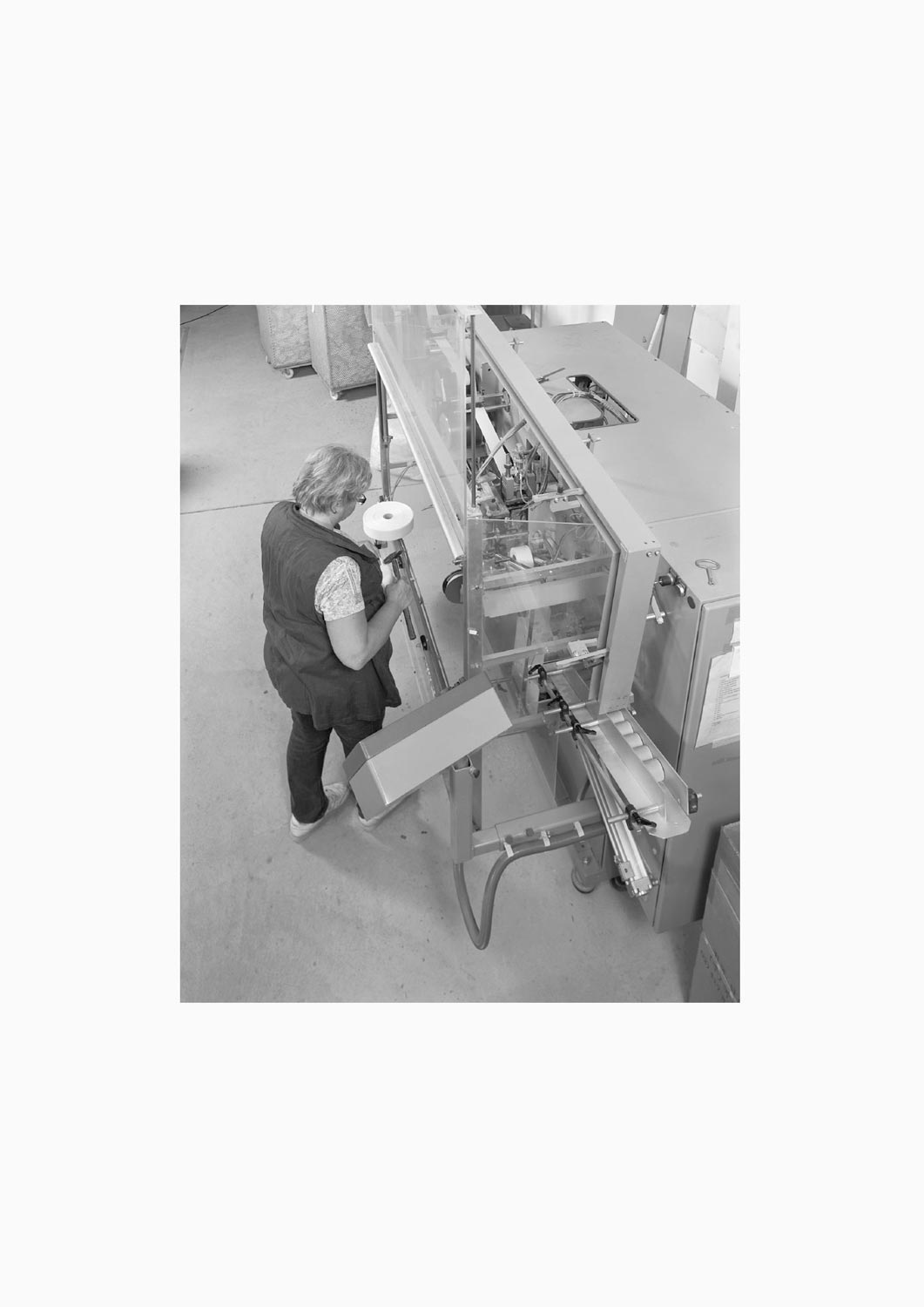 Eine Textilarbeiterin arbeitet an einer Maschine in der Firma M. Batex  Fotografie von Heiko Schäfer