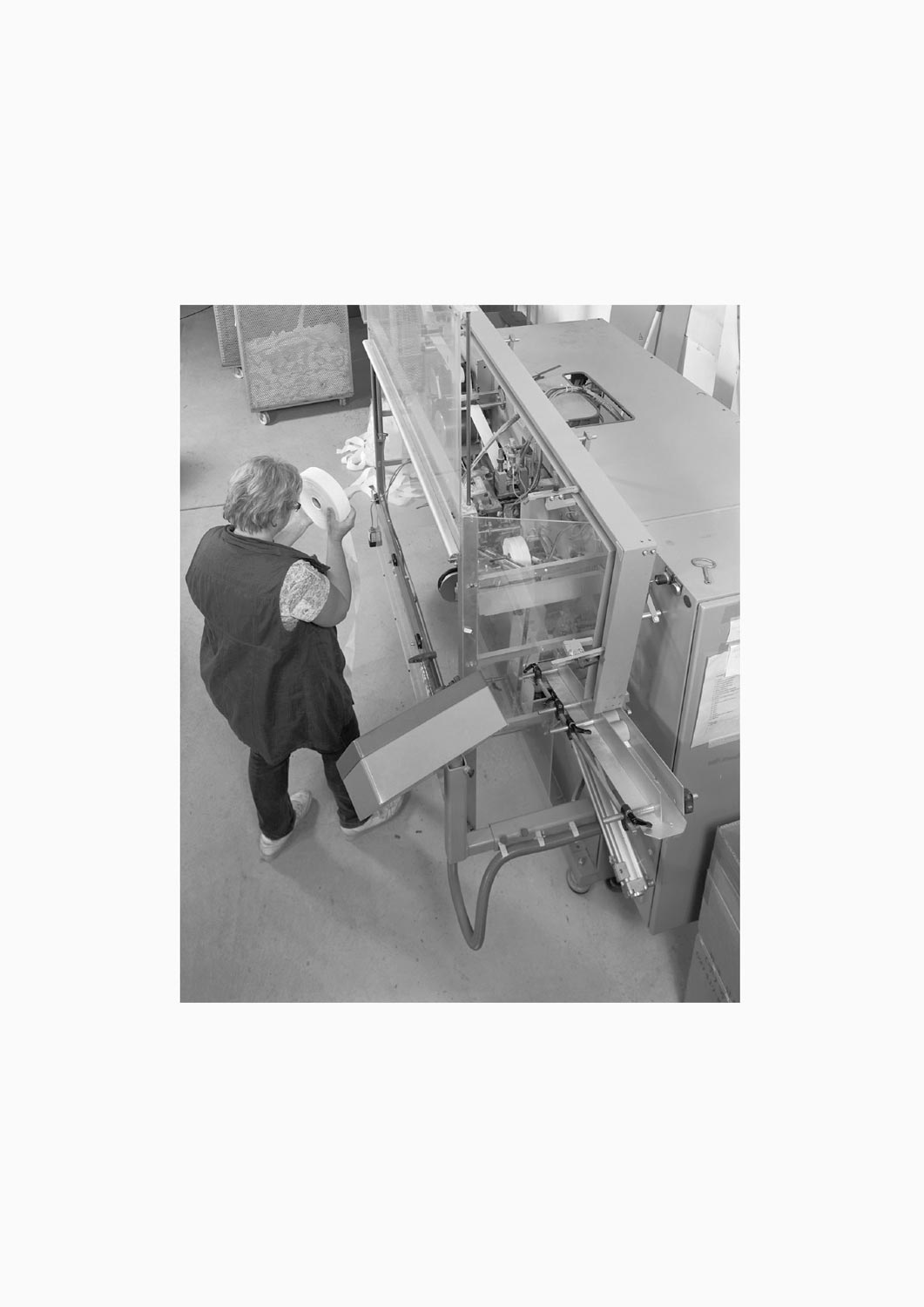 Eine Textilarbeiterin arbeitet an einer Maschine in der Firma M. Batex  Fotografie von Heiko Schäfer