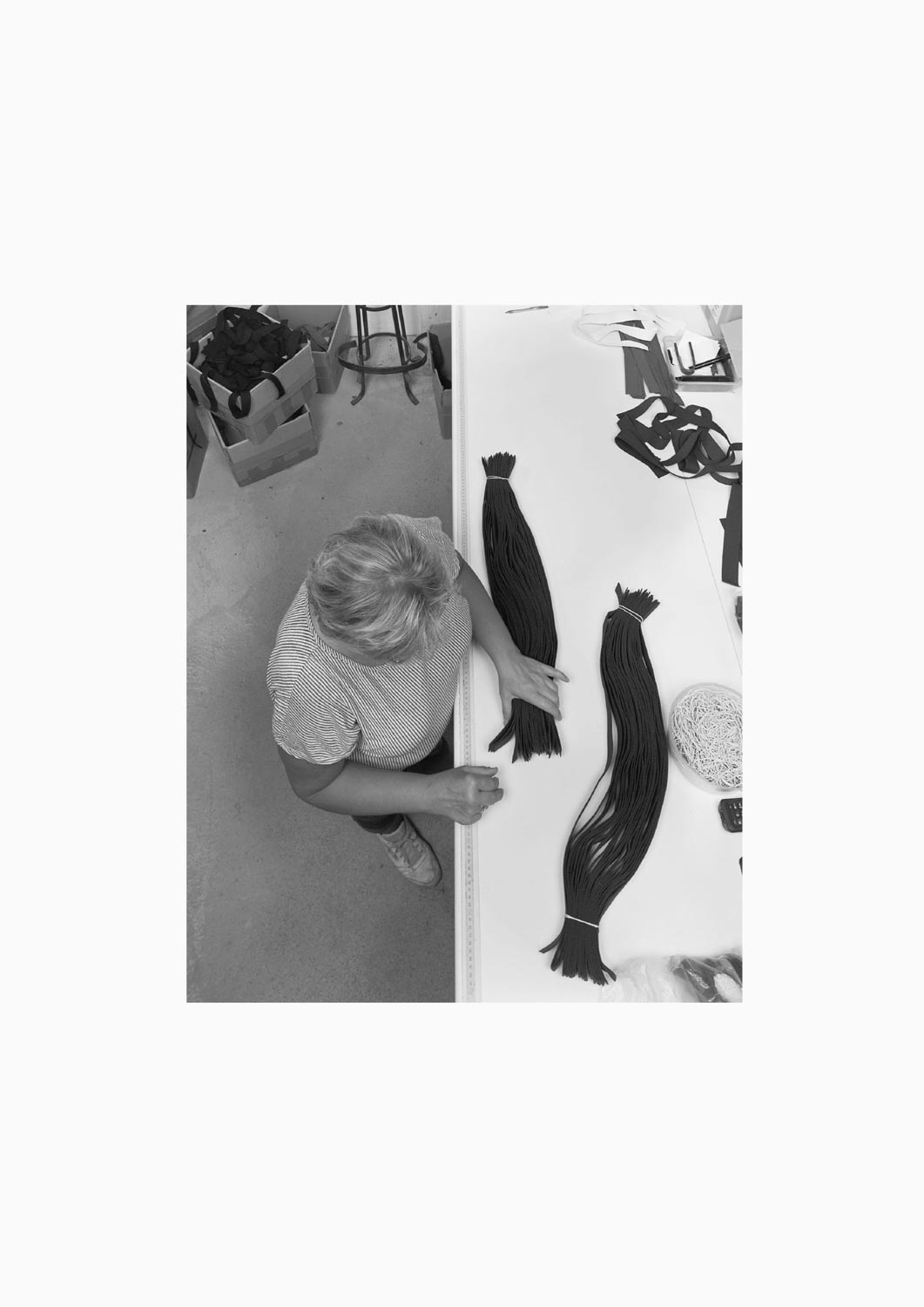 Eine Textilarbeiterin arbeitet an einem Arbeitstisch in der Firma M. Batex  Fotografie von Heiko Schäfer