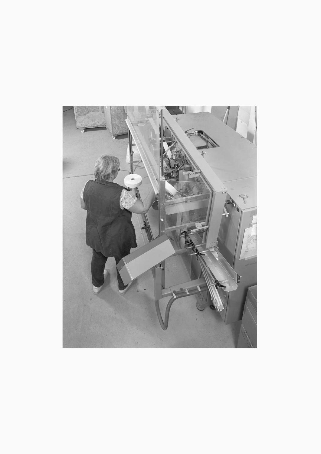 Eine Textilarbeiterin arbeitet an einer Maschine in der Firma M. Batex  Fotografie von Heiko Schäfer