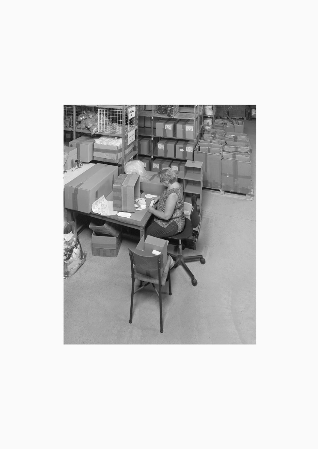 Eine Textilarbeiterin arbeitet an einem Arbeitstisch in der Firma M. Batex  Fotografie von Heiko Schäfer