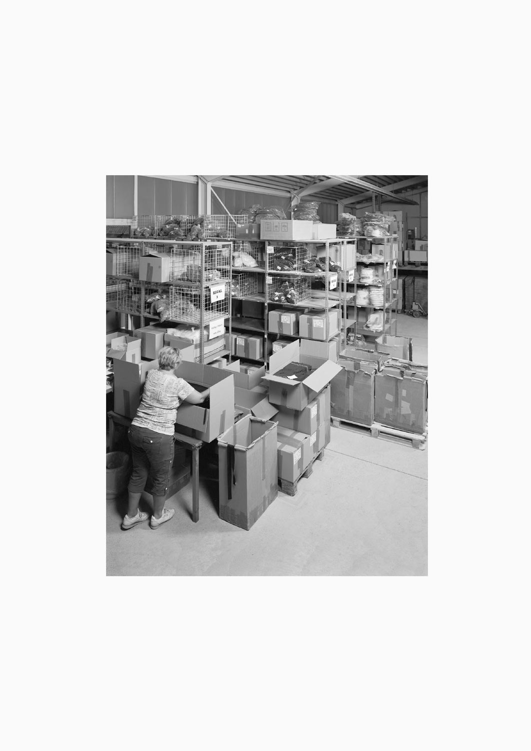 Eine Textilarbeiterin arbeitet an einem Arbeitstisch in der Firma M. Batex  Fotografie von Heiko Schäfer