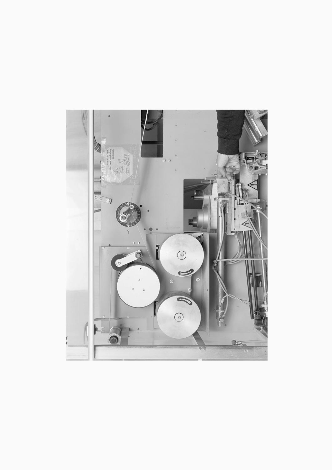 Eine Textilarbeiterin arbeitet an einer Maschine in der Firma M. Batex  Fotografie von Heiko Schäfer