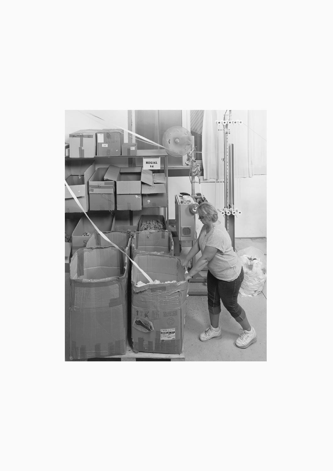 Eine Textilarbeiterin arbeitet an einer Maschine in der Firma M. Batex  Fotografie von Heiko Schäfer