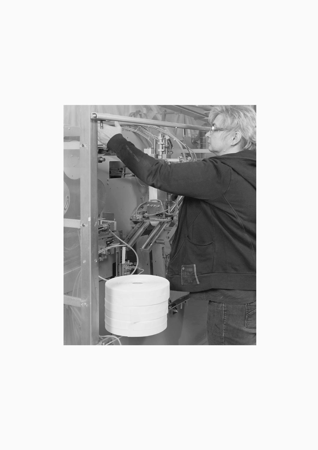 Eine Textilarbeiterin arbeitet an einer Maschine in der Firma M. Batex  Fotografie von Heiko Schäfer