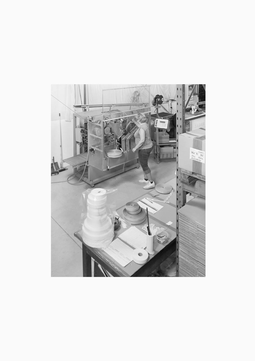 Eine Textilarbeiterin arbeitet an einer Maschine in der Firma M. Batex  Fotografie von Heiko Schäfer