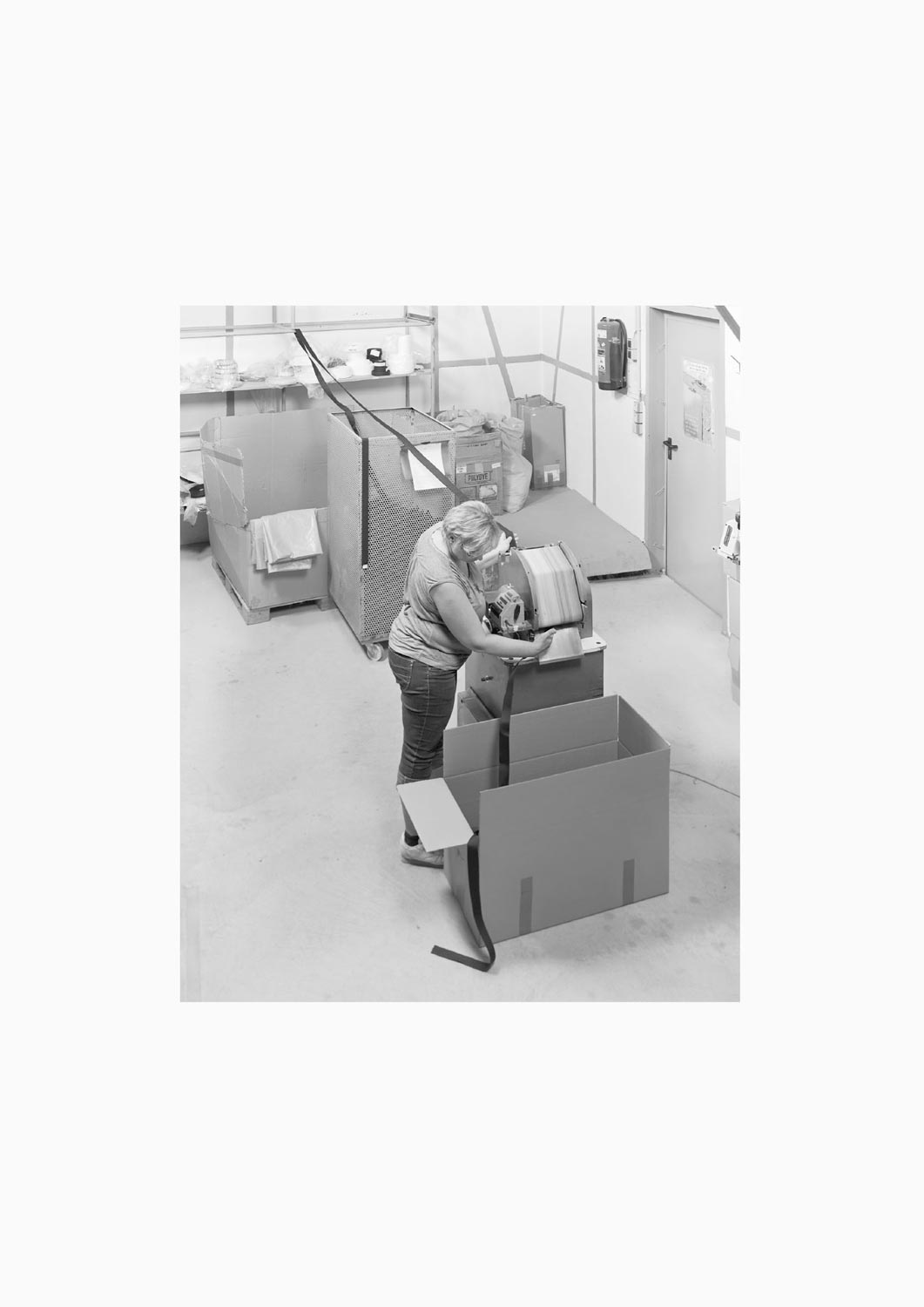 Eine Textilarbeiterin arbeitet an einer Maschine in der Firma M. Batex  Fotografie von Heiko Schäfer