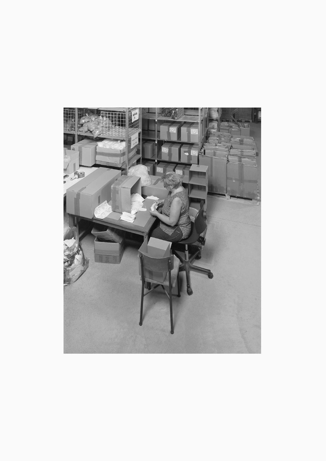 Eine Textilarbeiterin arbeitet an einem Arbeitstisch in der Firma M. Batex  Fotografie von Heiko Schäfer