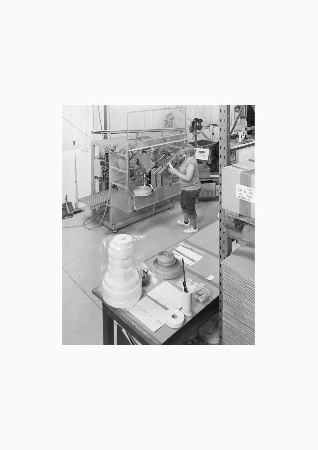 Eine Textilarbeiterin arbeitet an einer Maschine in der Firma M. Batex  Fotografie von Heiko Schäfer