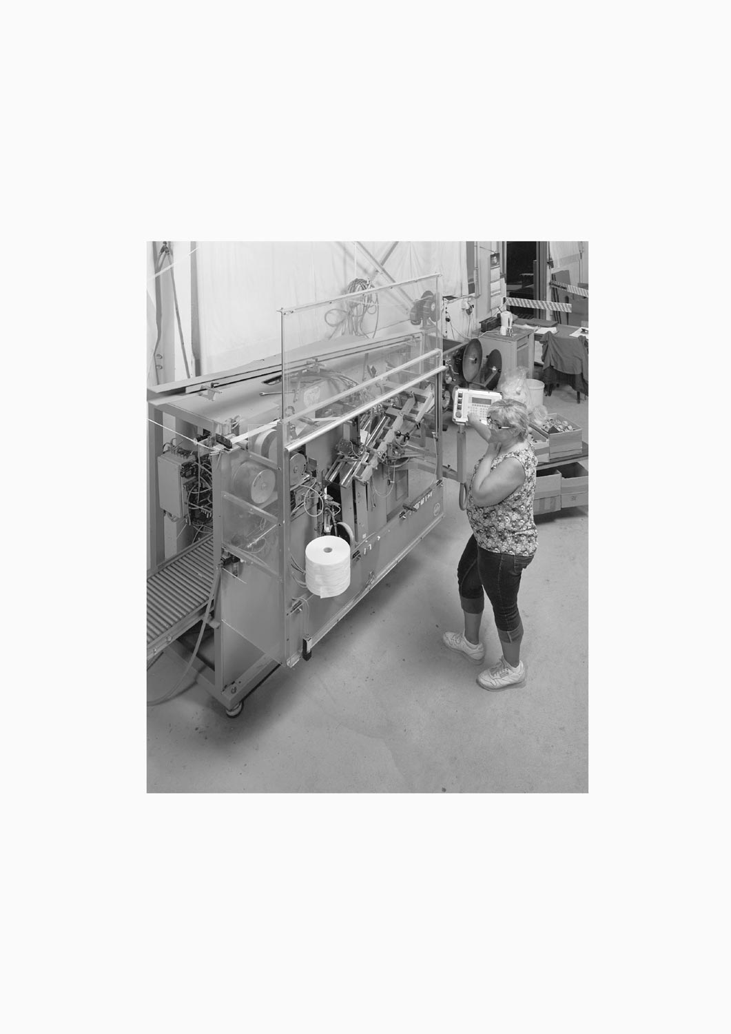 Eine Textilarbeiterin arbeitet an einer Maschine in der Firma M. Batex  Fotografie von Heiko Schäfer