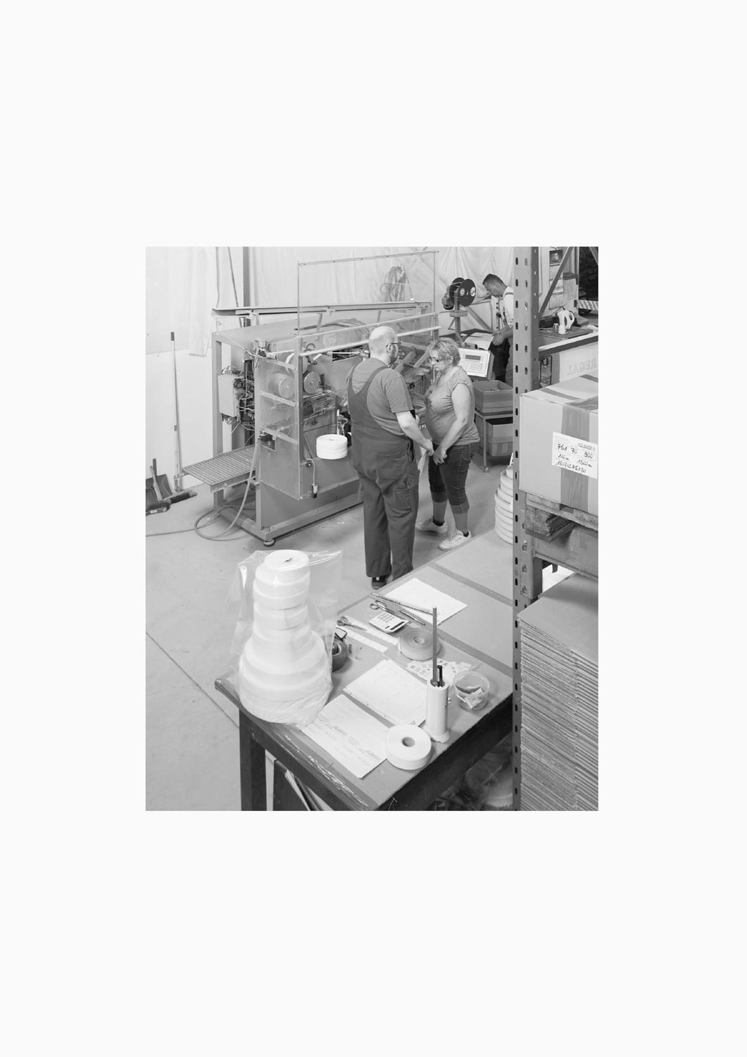 Eine Textilarbeiterin und ein Textilarbeiter stehen vor einer Maschine in der Firma M. Batex  Fotografie von Heiko Schäfer