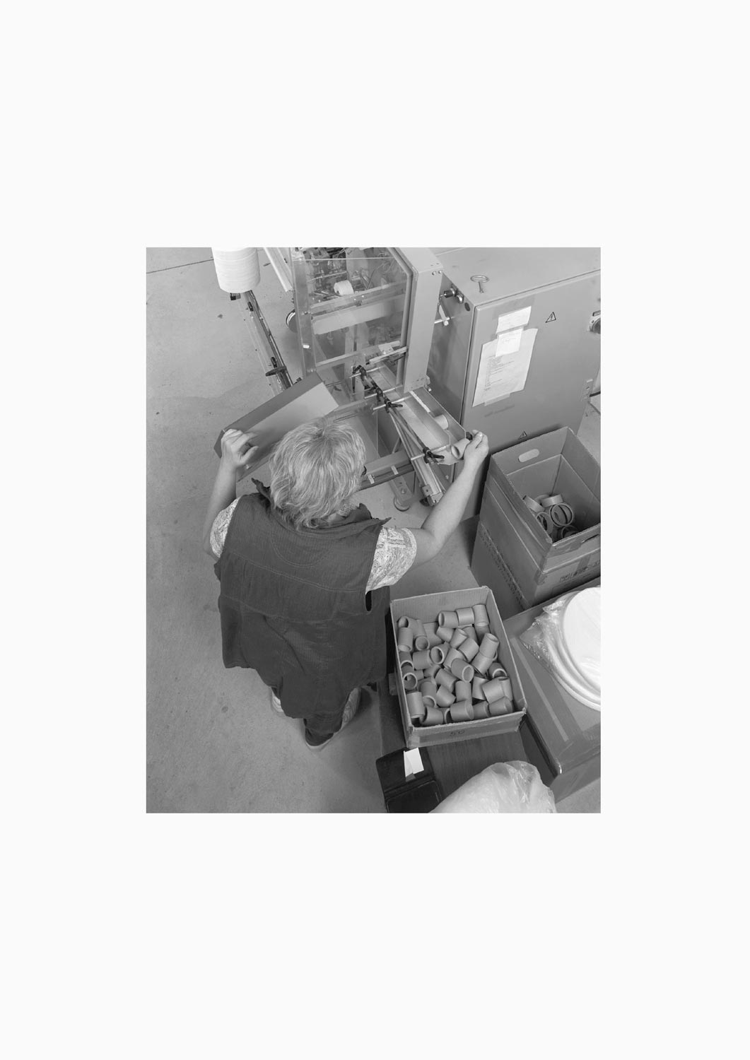 Eine Textilarbeiterin arbeitet an einer Maschine in der Firma M. Batex  Fotografie von Heiko Schäfer