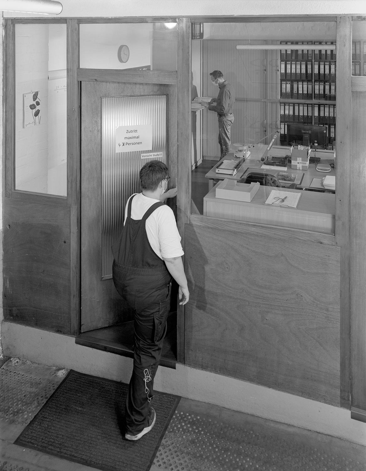 Eine Textilarbeiterin betritt das Büro ihres Vorarbeiters  Fotografie von Heiko Schäfer