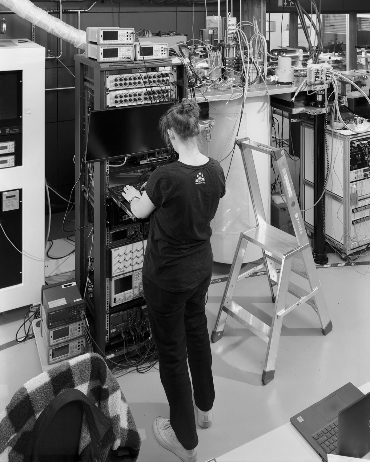 Eine Doktorandin kontrolliert ihren Versuchsaufbau im Supercomputerzentrum Jülich  Fotografie von Heiko Schäfer